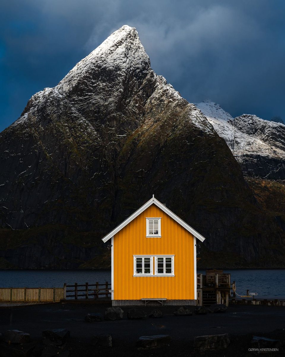 Gul rorbu foran en bratt, snødekt fjelltopp